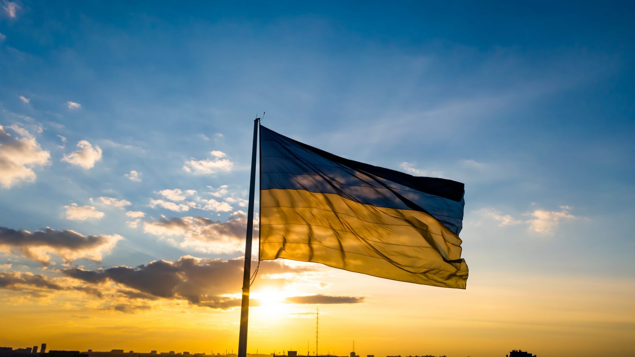 Flag of Ukraine against the backdrop of sunrise. Yellow-blue flag of independent Ukraine.