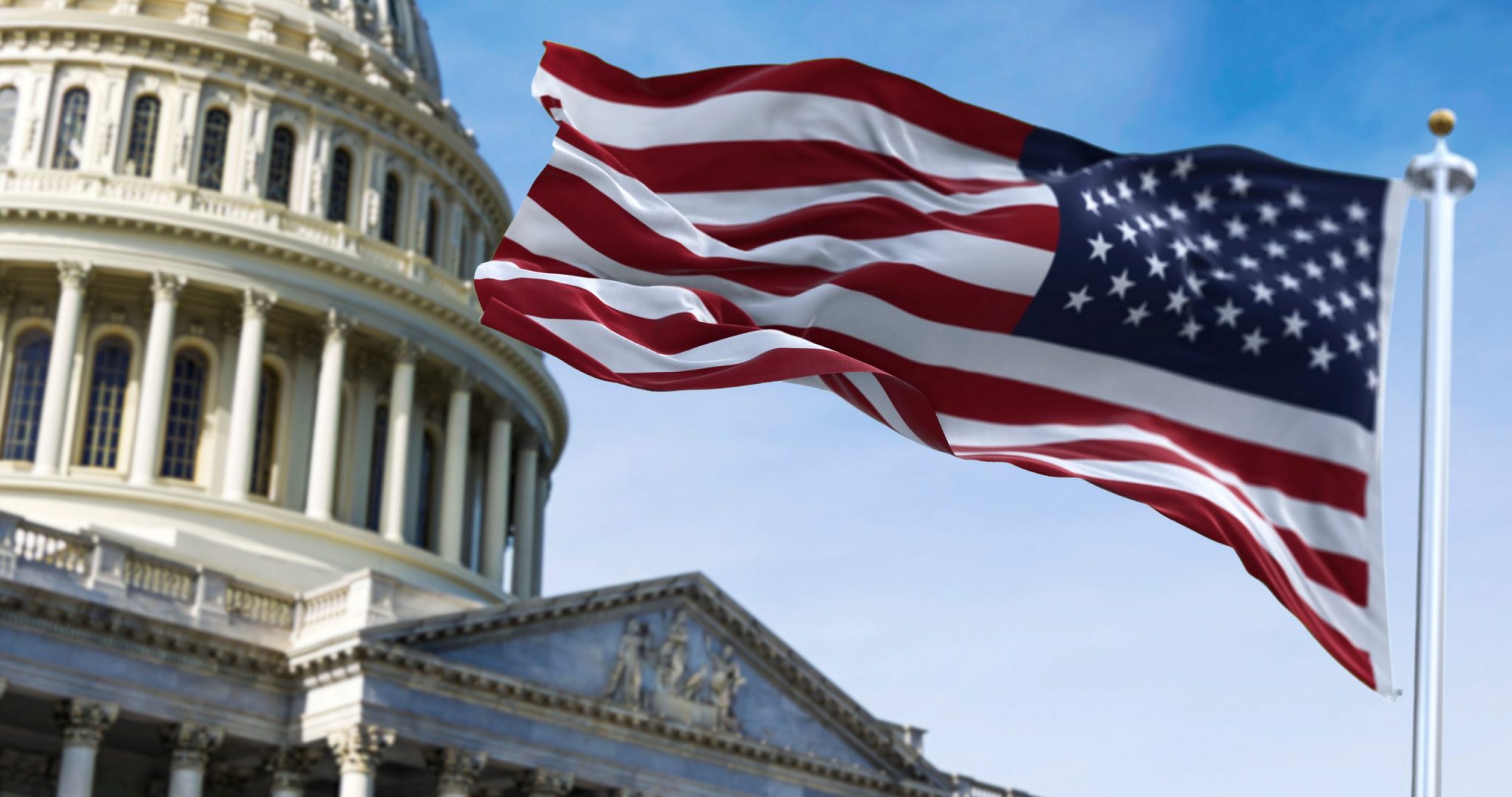 American flag waving with the US Capitol Hill in the background