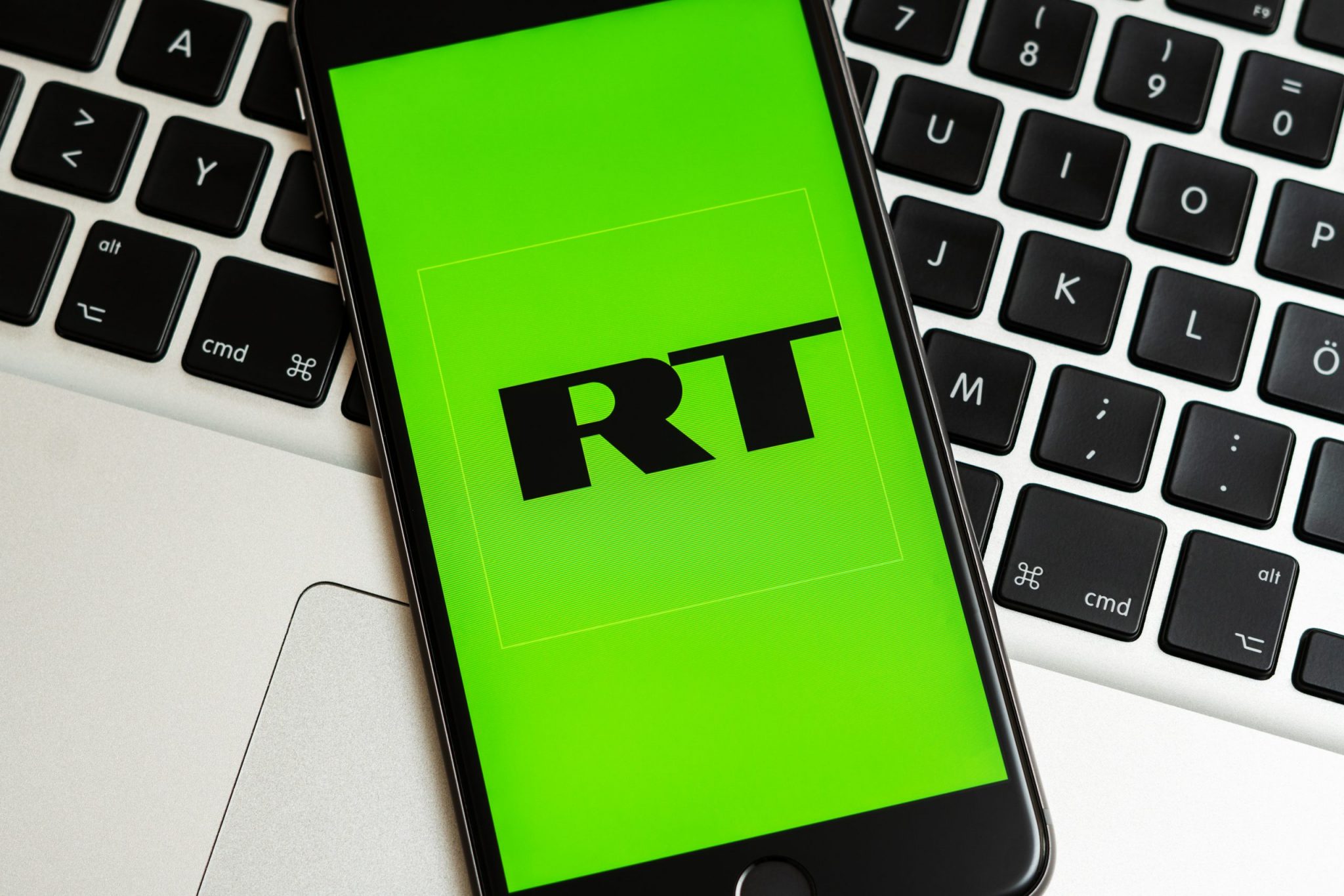 New York / USA - 02/23/2019: Black phone with logo of news media Russia Today (RT) on the screen. RT media icon.