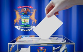 Michigan flag, hand dropping ballot card into a box - voting, election concept - 3D illustration