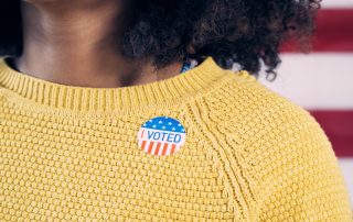Young Gen Z Voter Wearing Sticker After Voting in Election