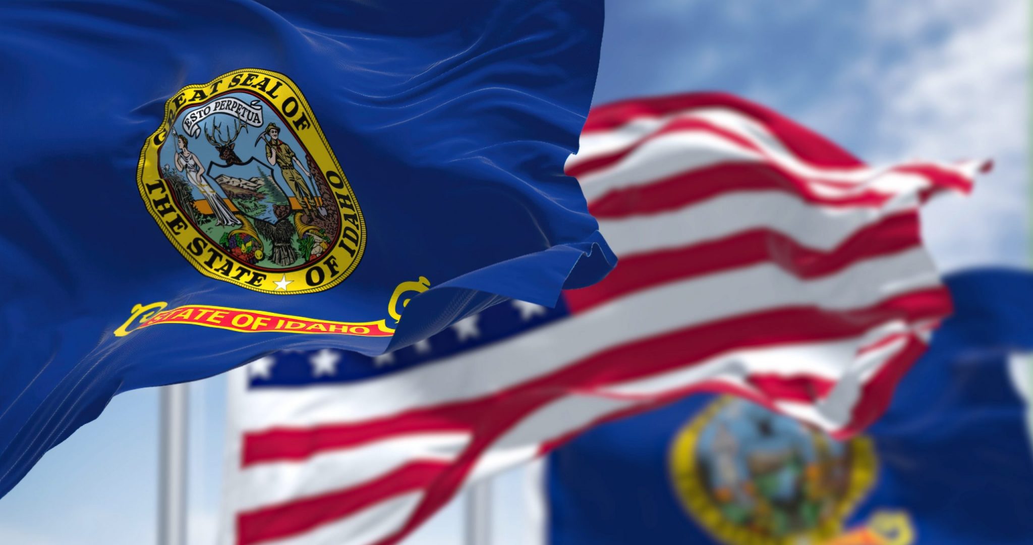The Idaho state flag waving along with the national flag of the United States of America.