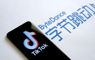 Stone UK - August 2 2020: TikTok app logo on the screen and ByteDance company logo on the blurred background. Selective focus.