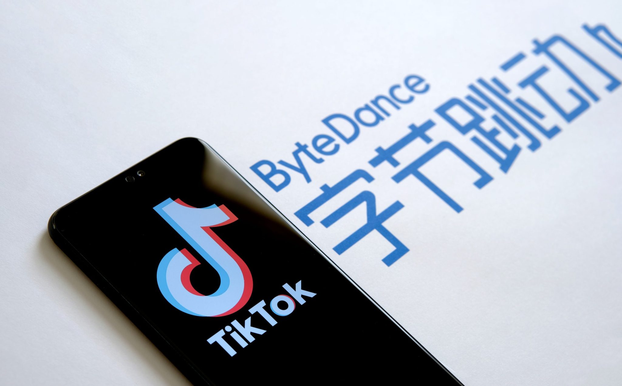 Stone UK - August 2 2020: TikTok app logo on the screen and ByteDance company logo on the blurred background. Selective focus.