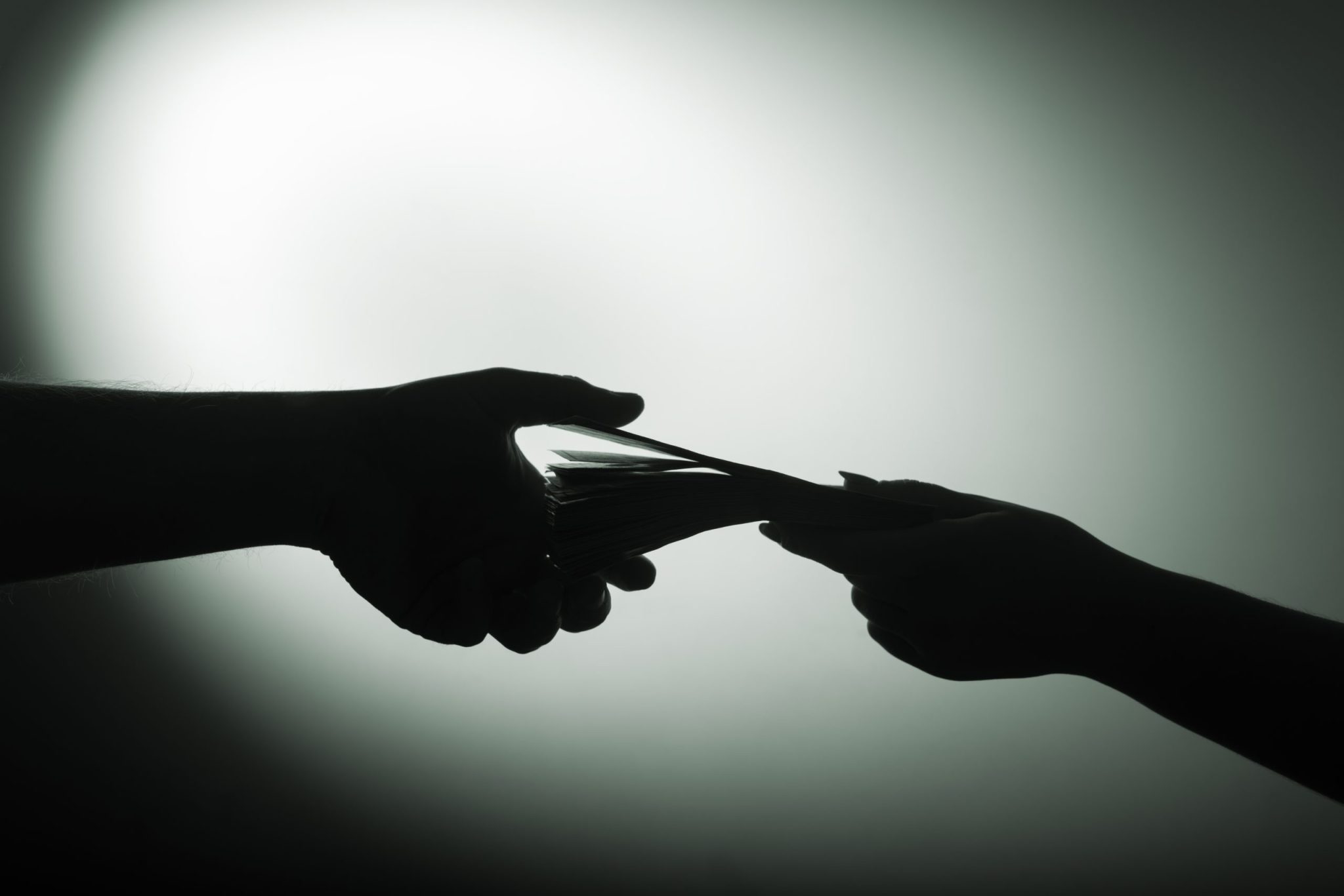 dark economy. Two hands with money