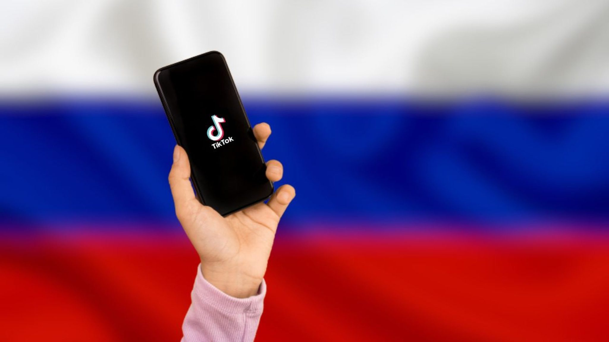 TikTok in Russia - TikTok in mobile with Russian Flag background - tiktok app in russia